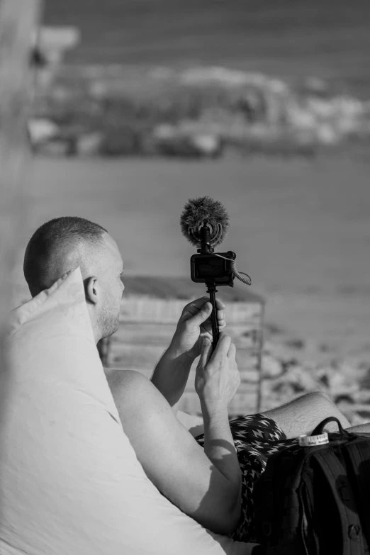 a man taking a picture of soing while lying on the beach