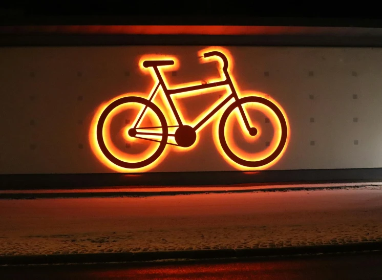 a bike lit up against a wall that is dark