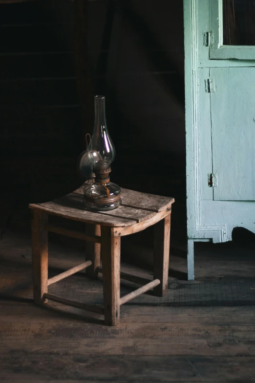 an old table and lamp is shown in the dark