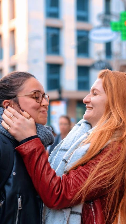 two women hug each other while one looks away