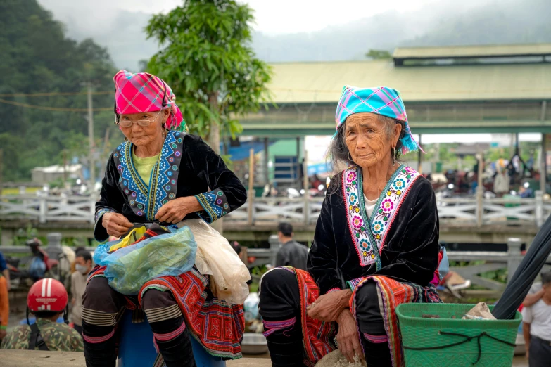 two women sitting down and looking at soing in their hands