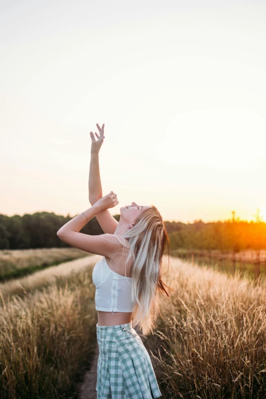 a beautiful woman wearing a white top and green plaid shorts