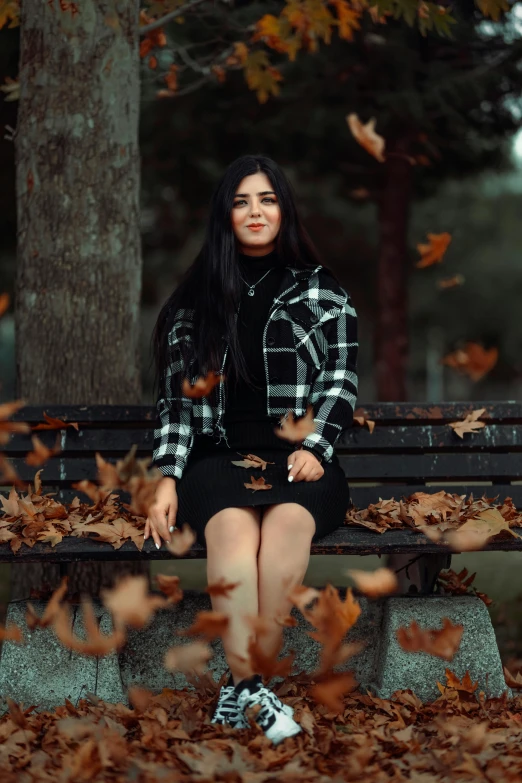 a woman with long hair is sitting on a bench