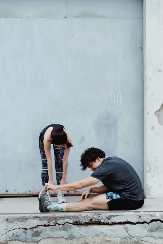 two people are crouching down while looking at their feet