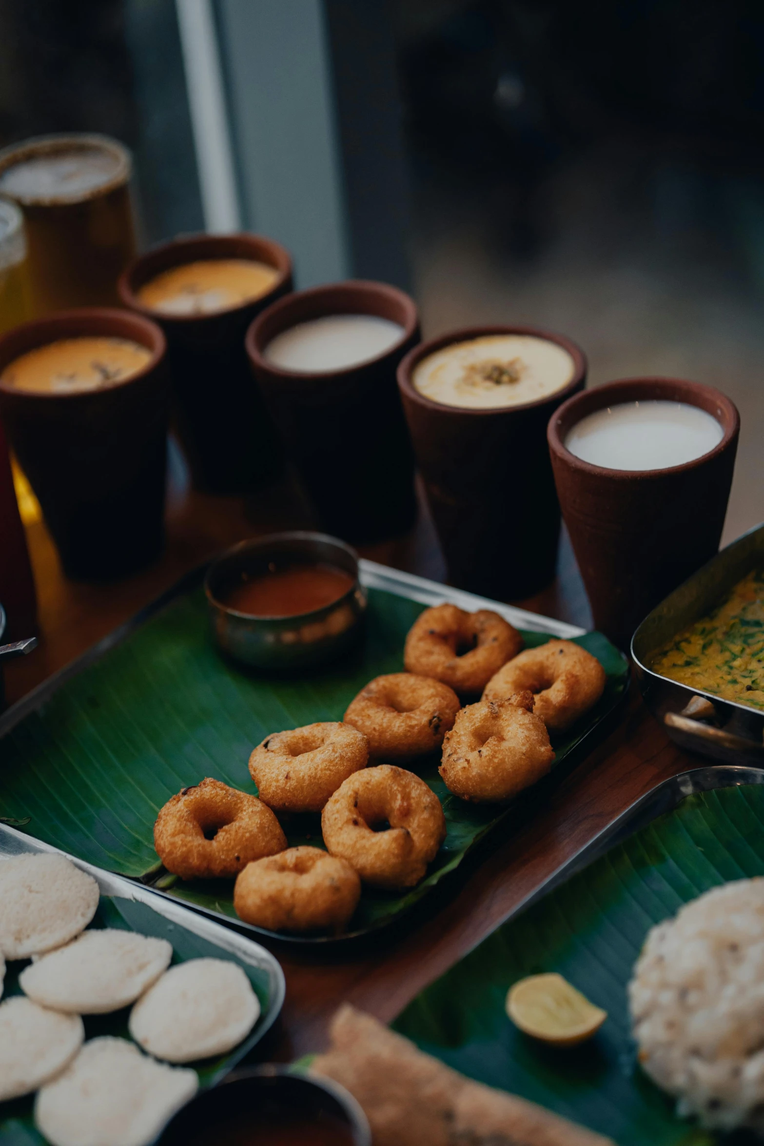 several plates with drinks and donuts on them