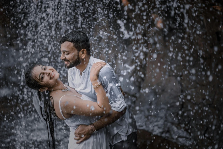 a young couple emcing under water droplets