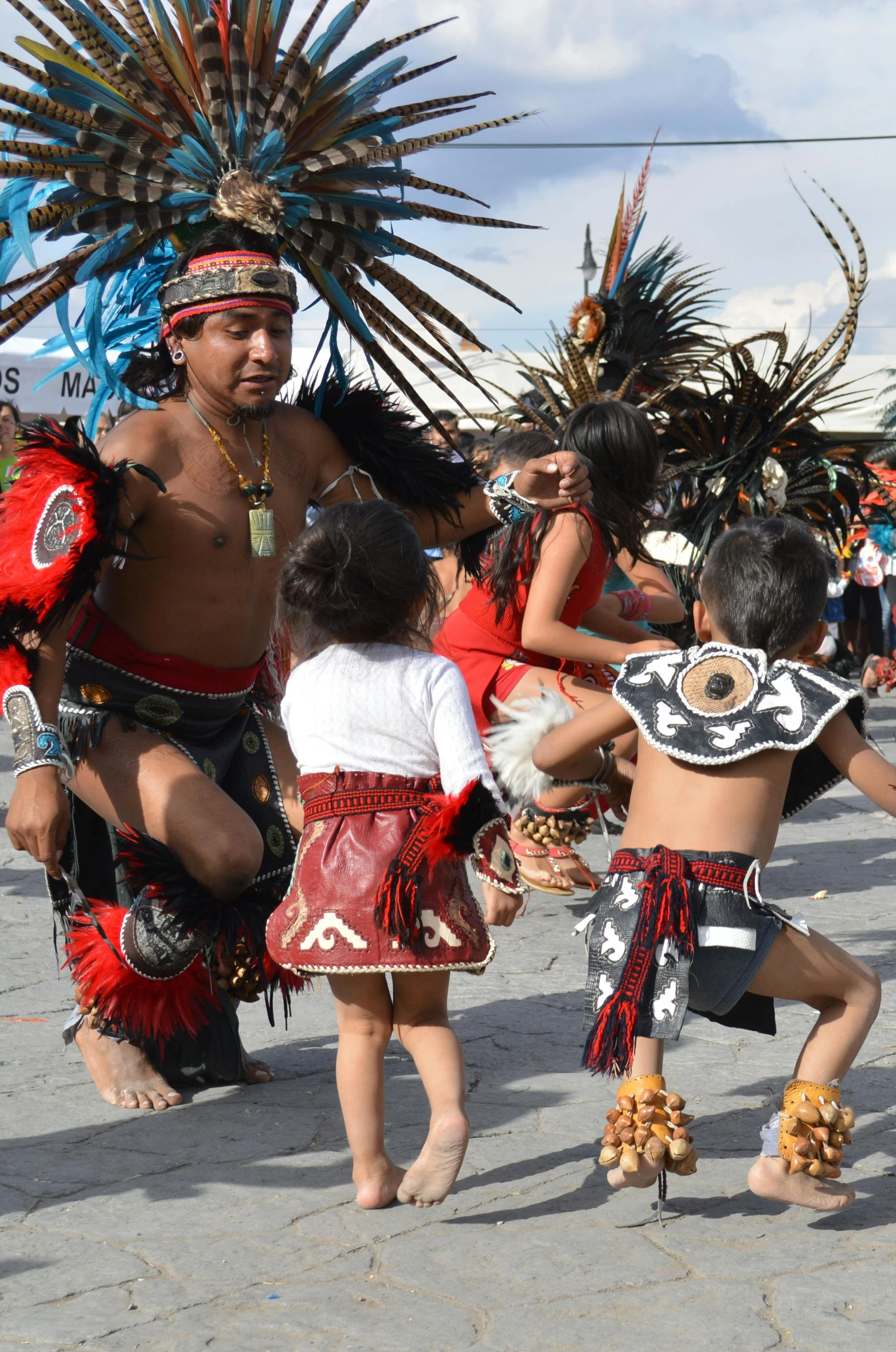 some young children dancing on the pavement in a village