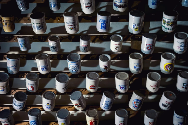 multiple coffee cups lined up on a shelf