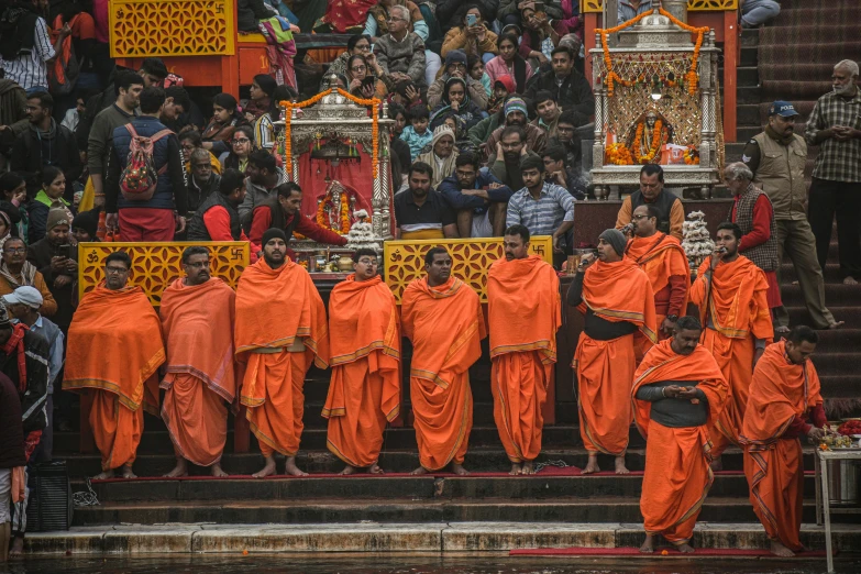 many people dressed in orange standing by a group