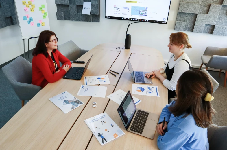 several women at a meeting with laptop computers