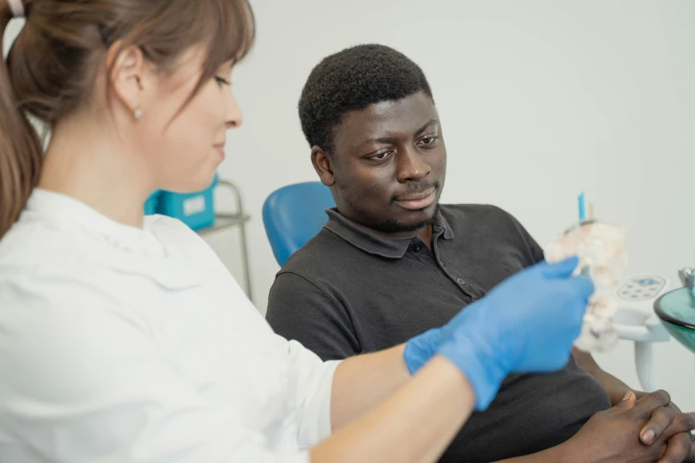 there are a male dentist showing a female patient