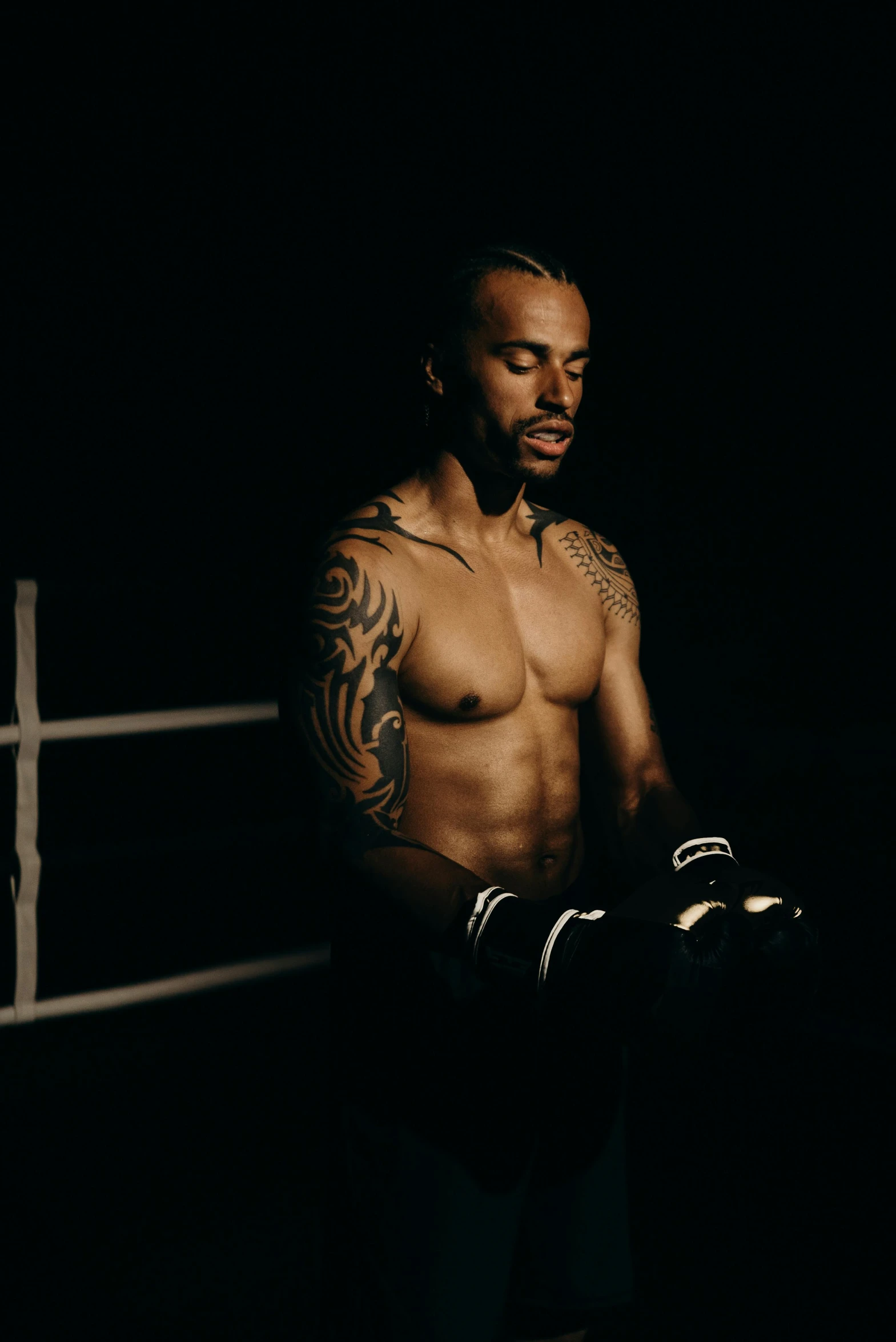 a black man with his arms crossed standing in a boxing ring