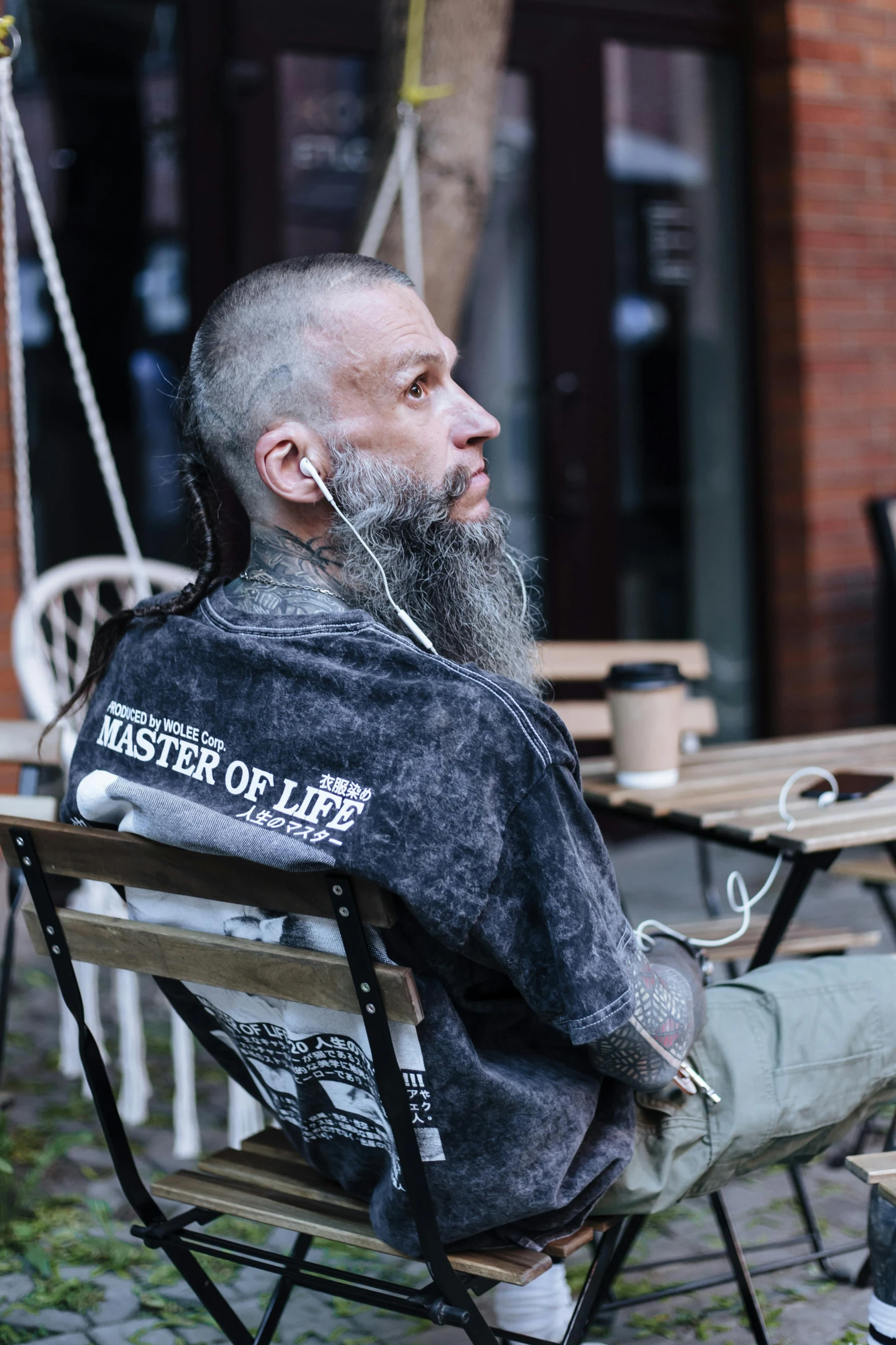 a man with a beard sitting in an outdoor chair