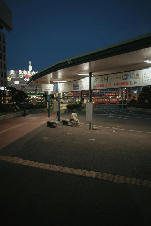 an empty parking lot with a gas station at night