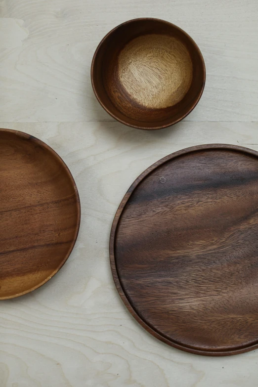 wooden bowls sitting on a table with one empty