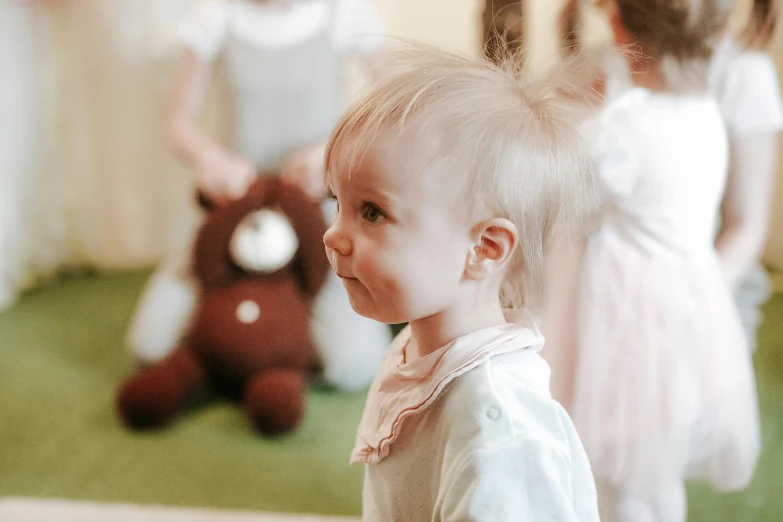 an adorable little girl standing in front of a group of other small girls