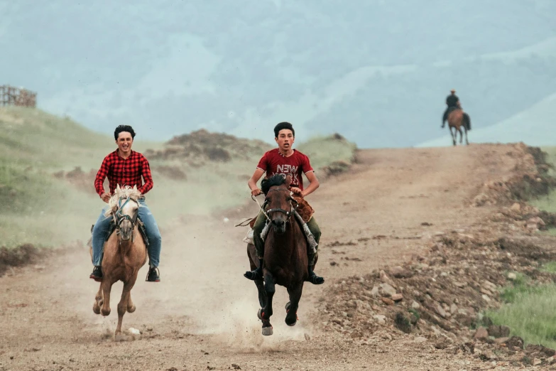 two men are riding horses and horseback down a path