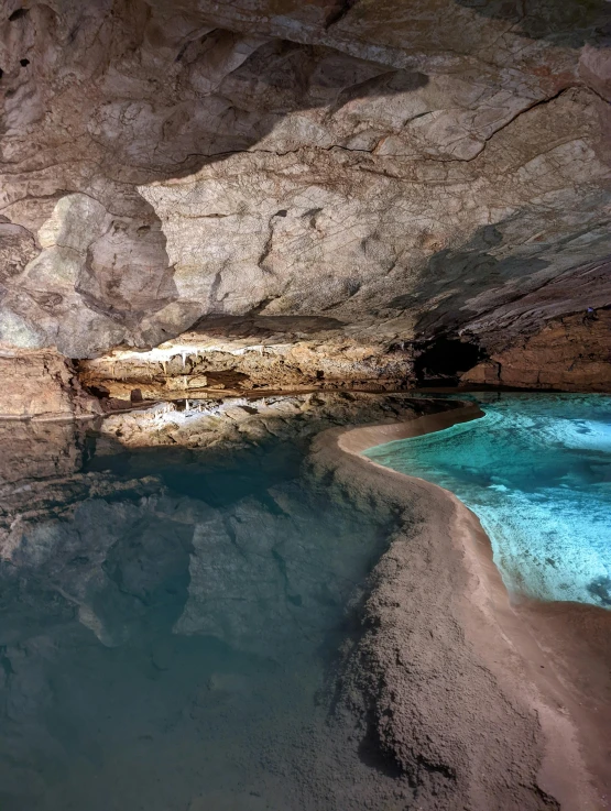 a blue pool in the rocks of a cave