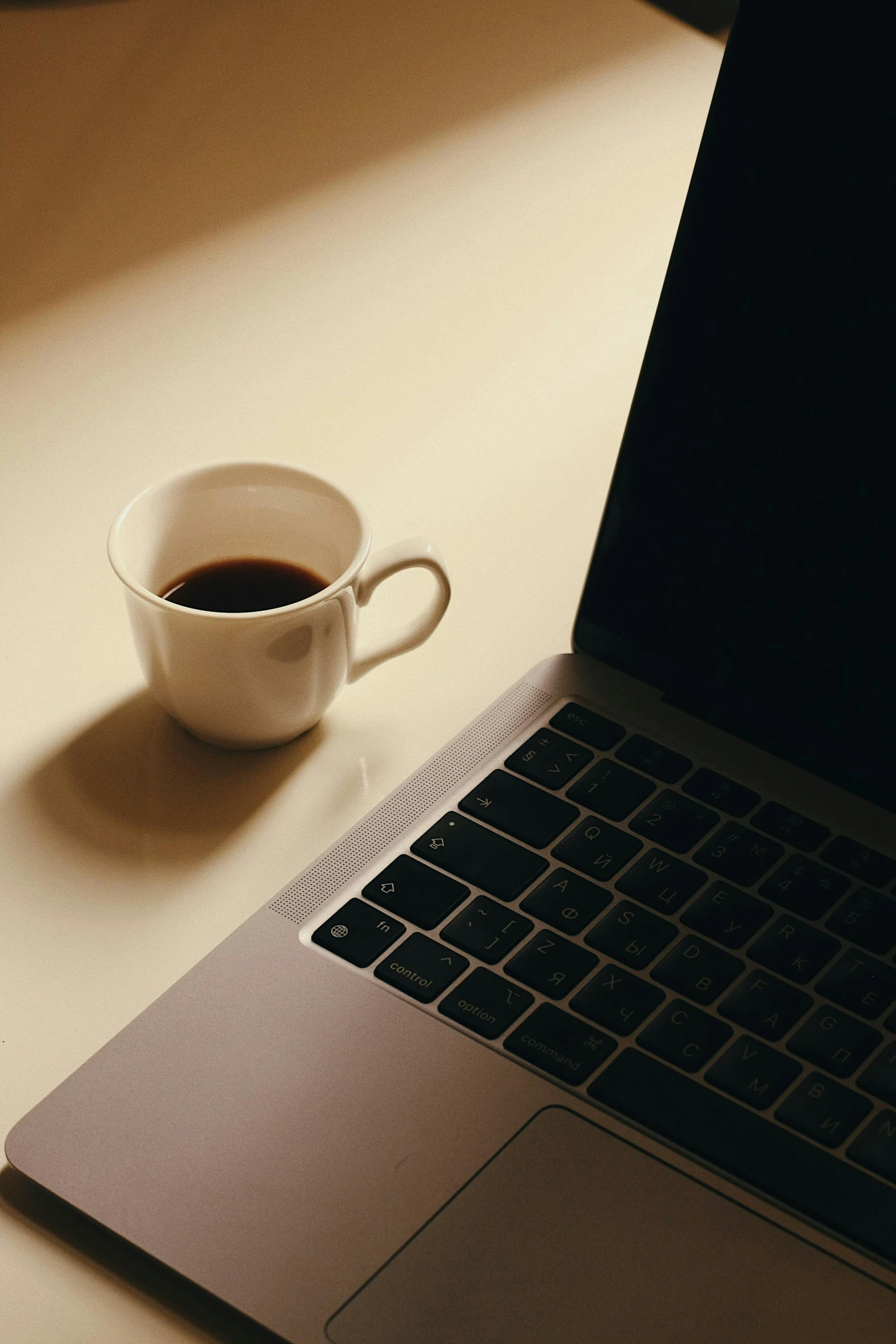 a laptop with coffee cup on a table