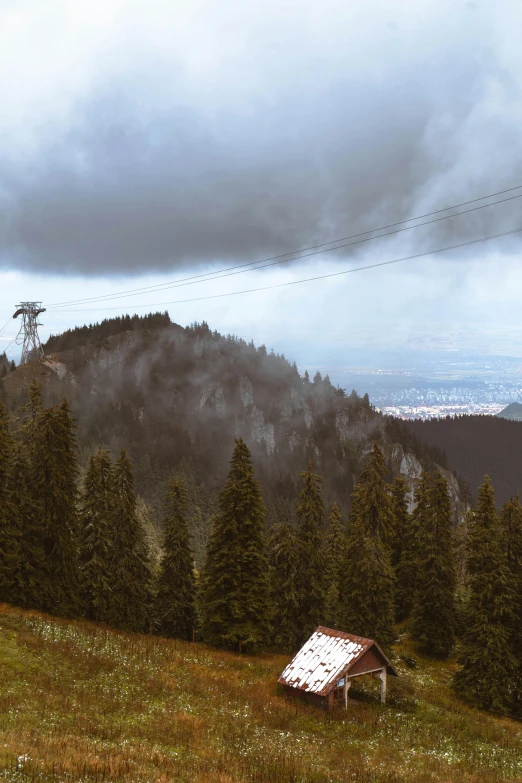 a house is standing on a hilltop with clouds in the background