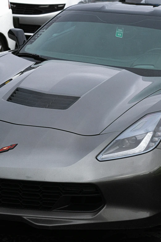 black sports car parked in parking lot next to other cars