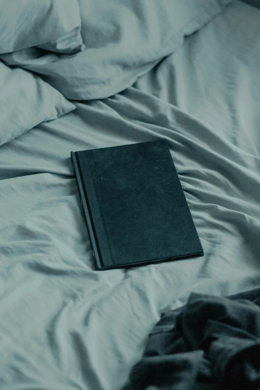 book sitting on a bed with white sheets
