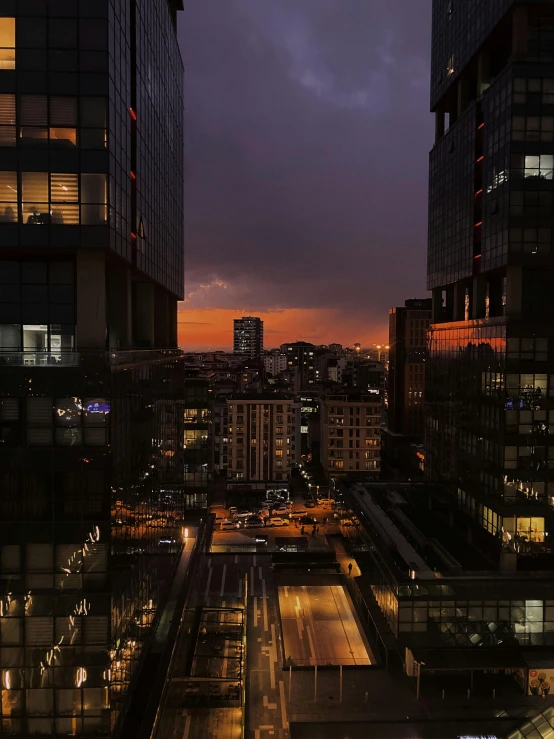 a view of a city skyline at night, from the rooftop of an apartment building