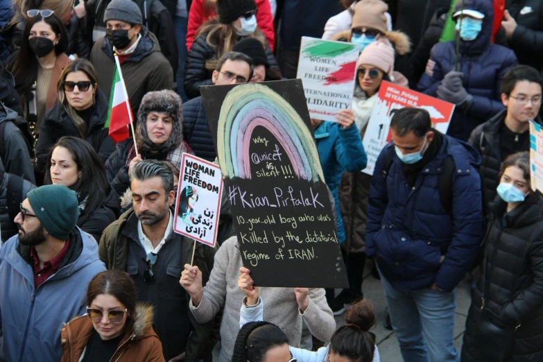 a crowd of people are holding signs and talking