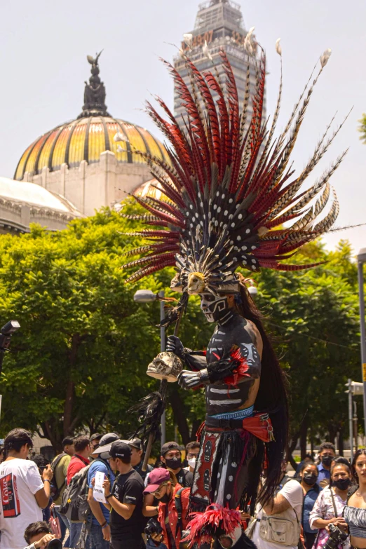 a person dressed in costume, walking on street near buildings