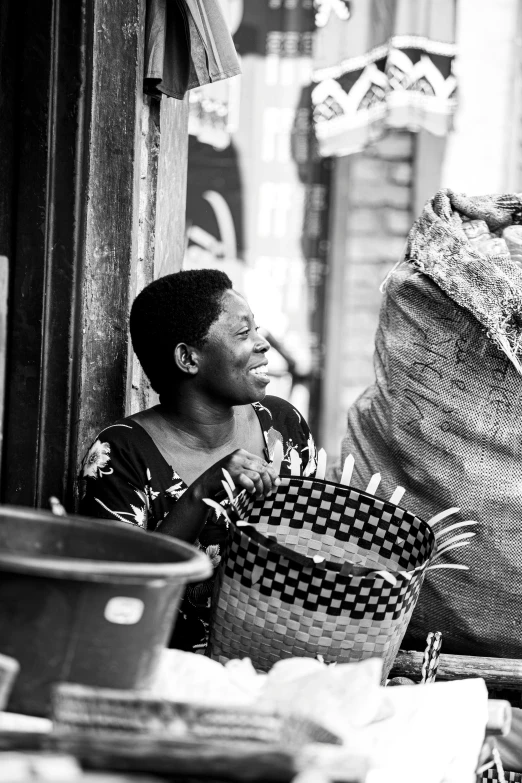 a black and white po of a woman standing next to a bunch of baskets