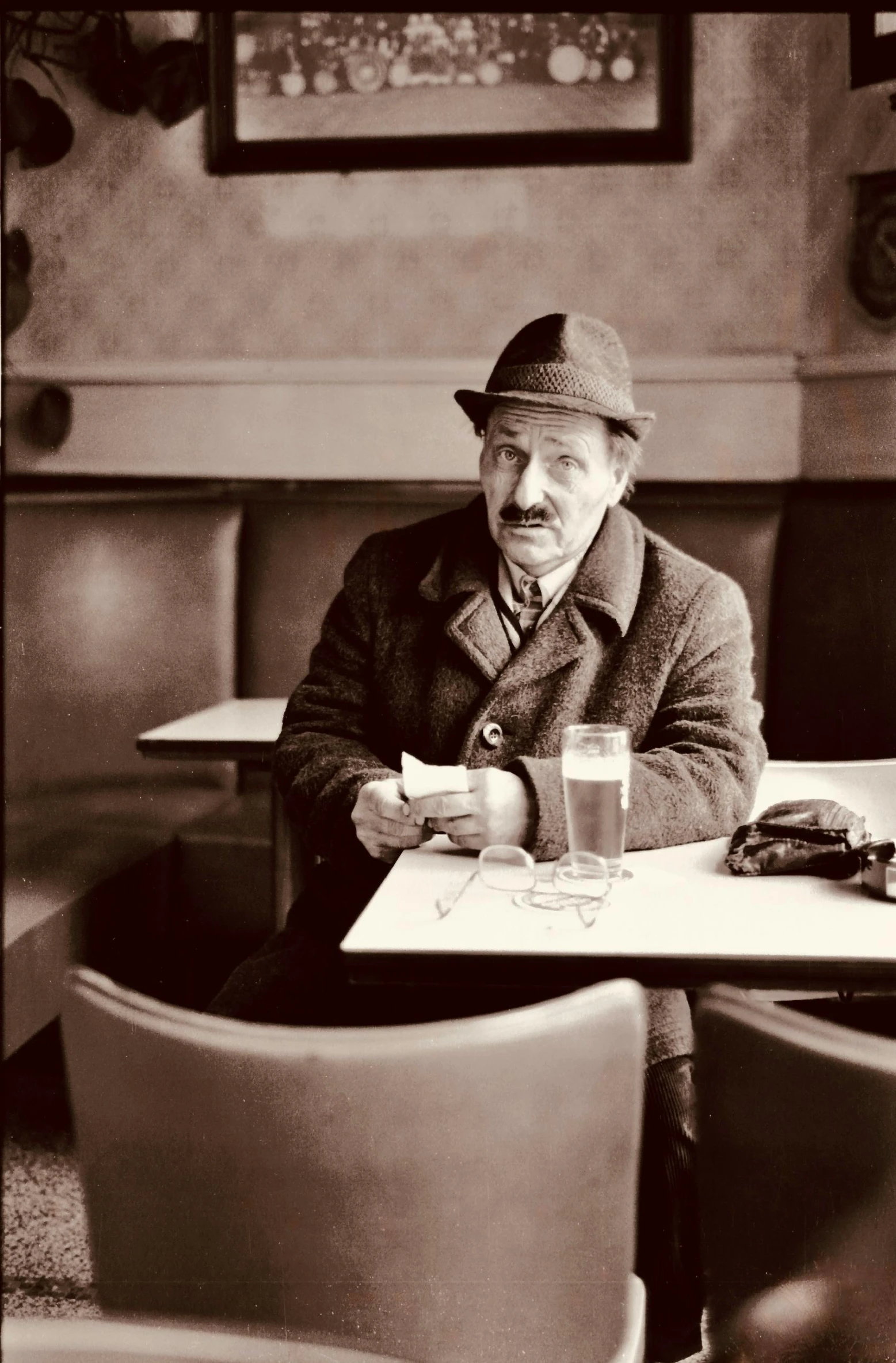 black and white po of a man wearing a hat at a restaurant