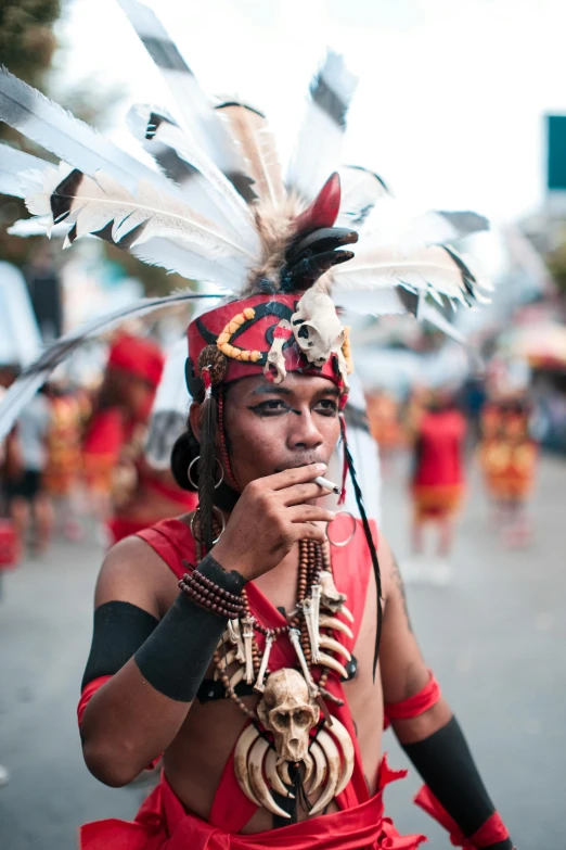 a man with feathers on his head wearing red and black feathers