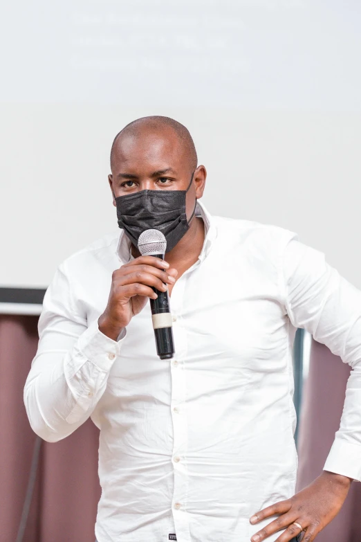 a man holding a microphone in front of his face mask