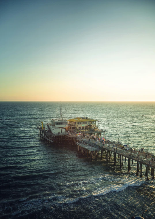 an old pier in the ocean during sunrise