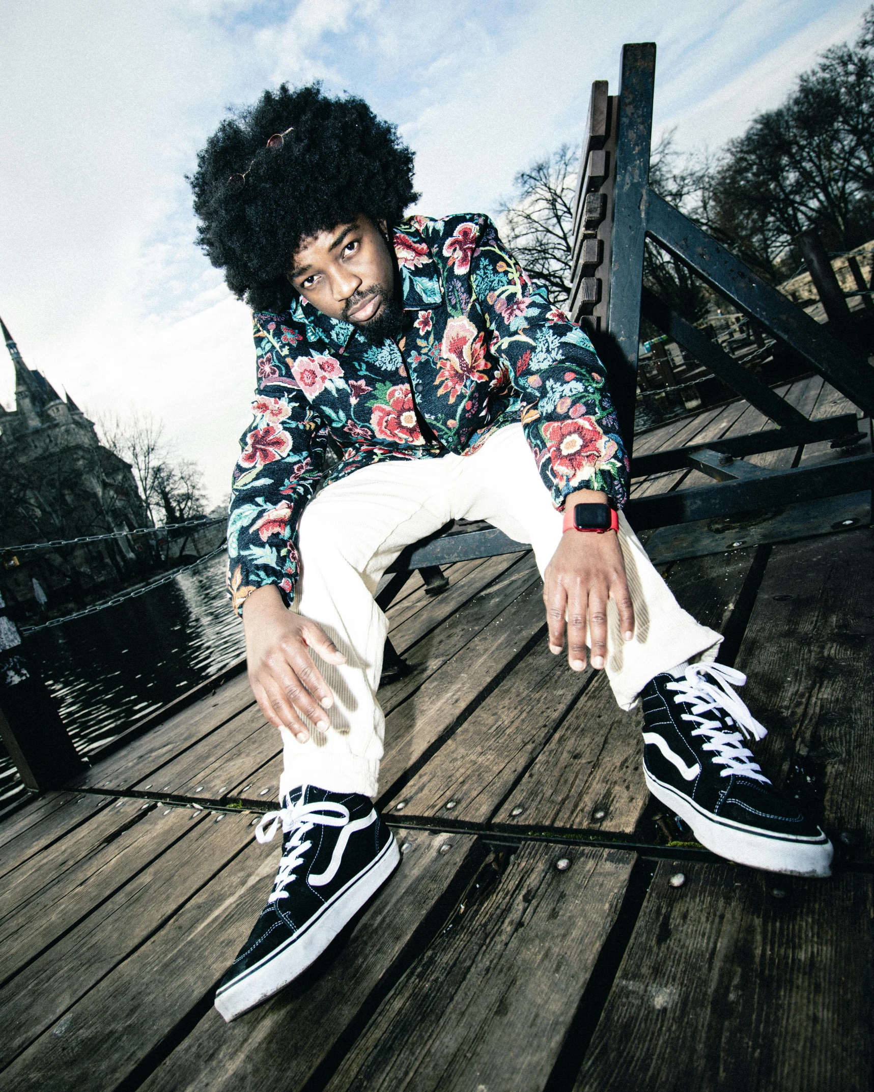 a black haired man posing on top of a wood floor