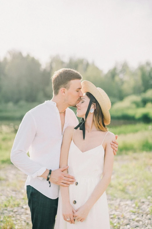 an engaged couple standing together on a beach in their wedding day