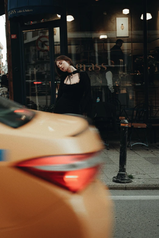 a woman is walking past the shop window in a dark city