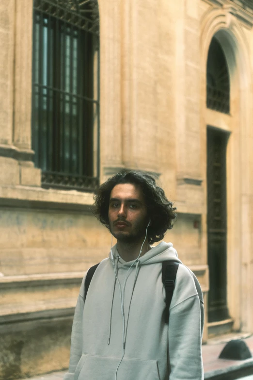 a young man is standing next to a building