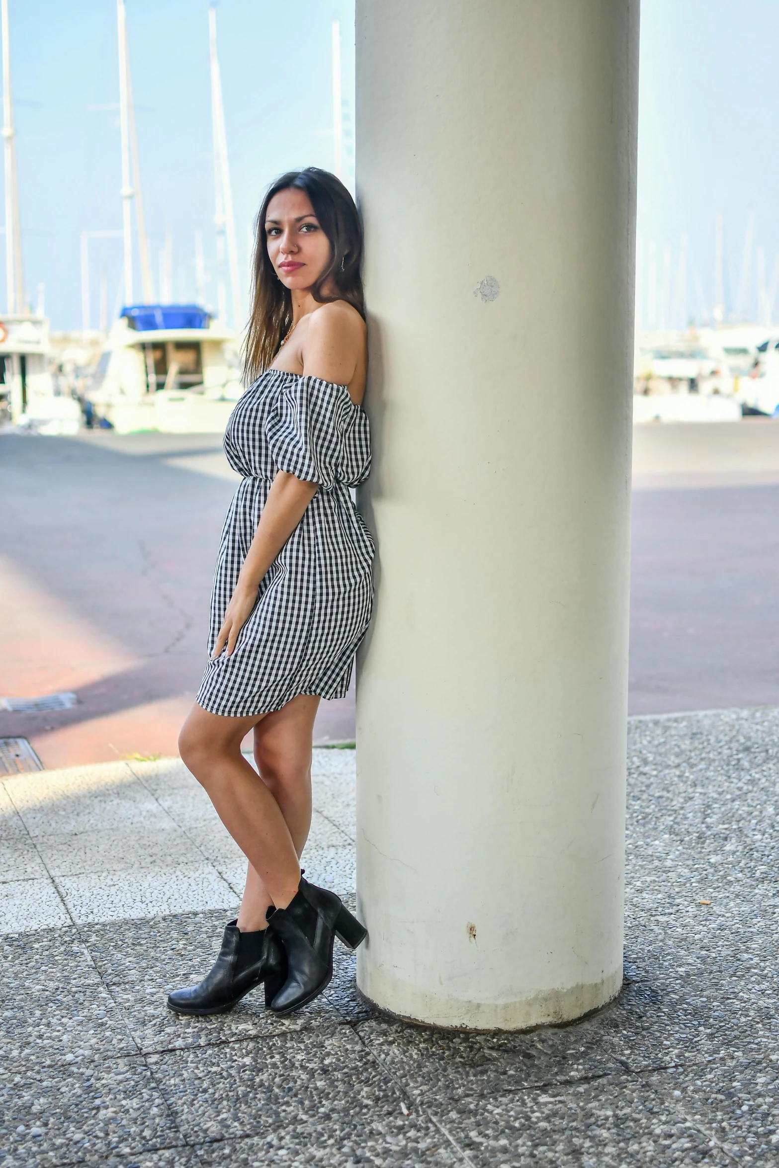 a woman poses in front of a large pillar