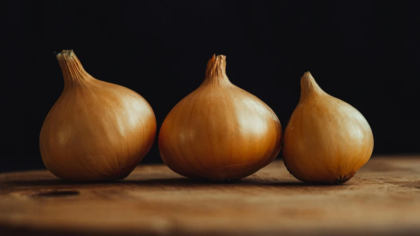 three onions on a table ready to be sold