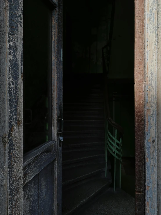 a wooden door leading into a building next to stairs