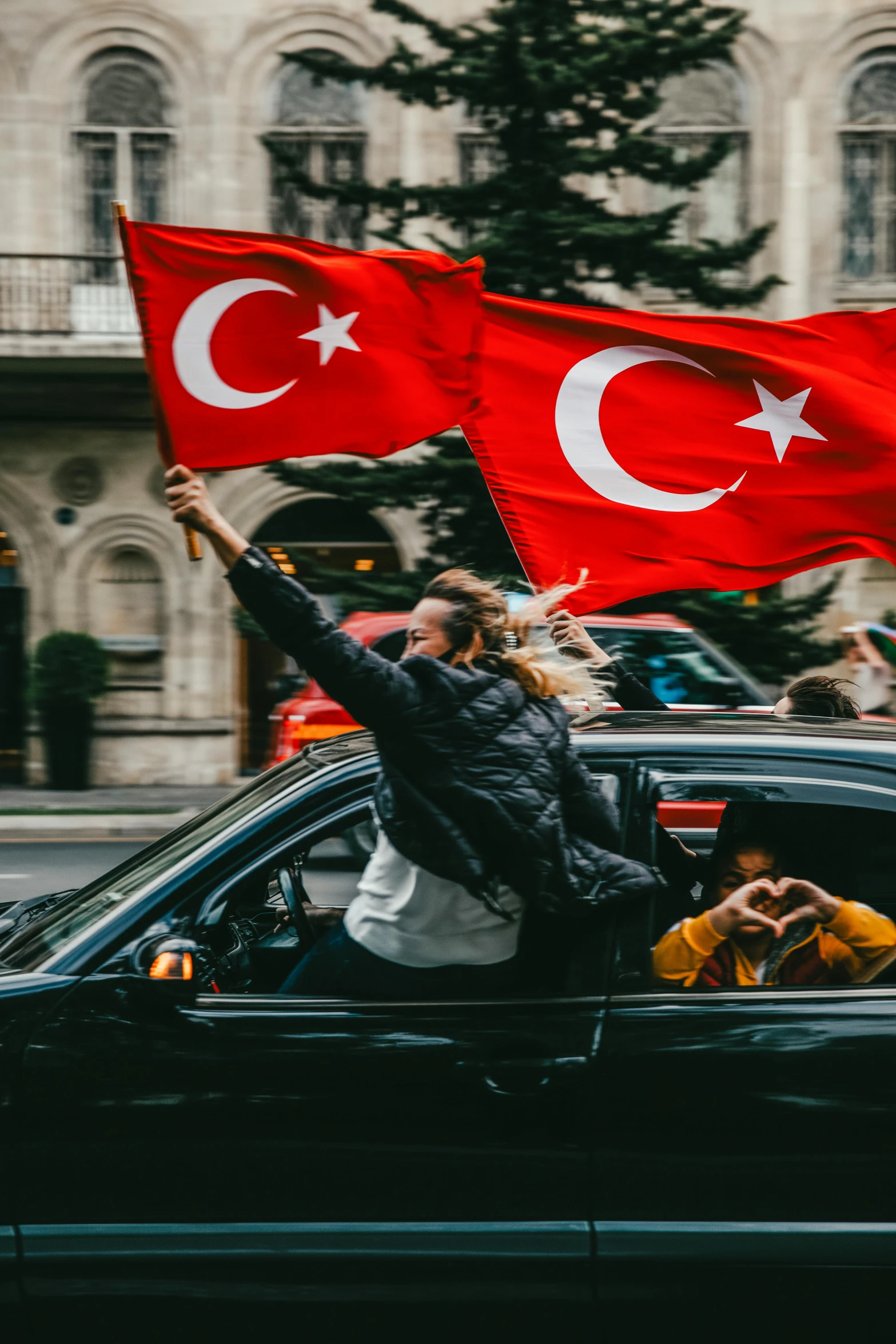 some people on a city street holding flags