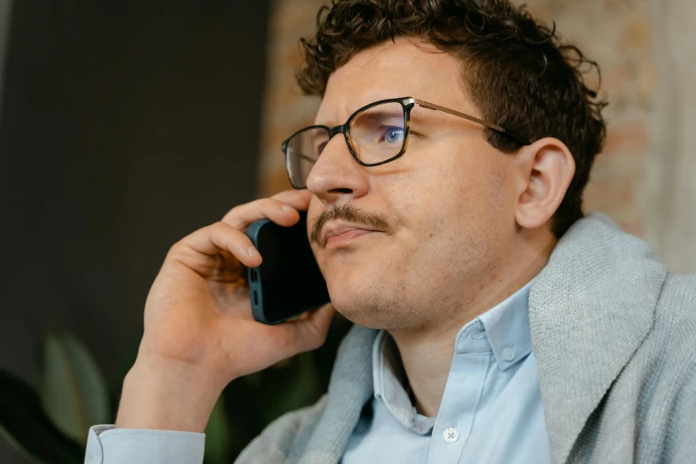 a man with glasses talking on a cell phone
