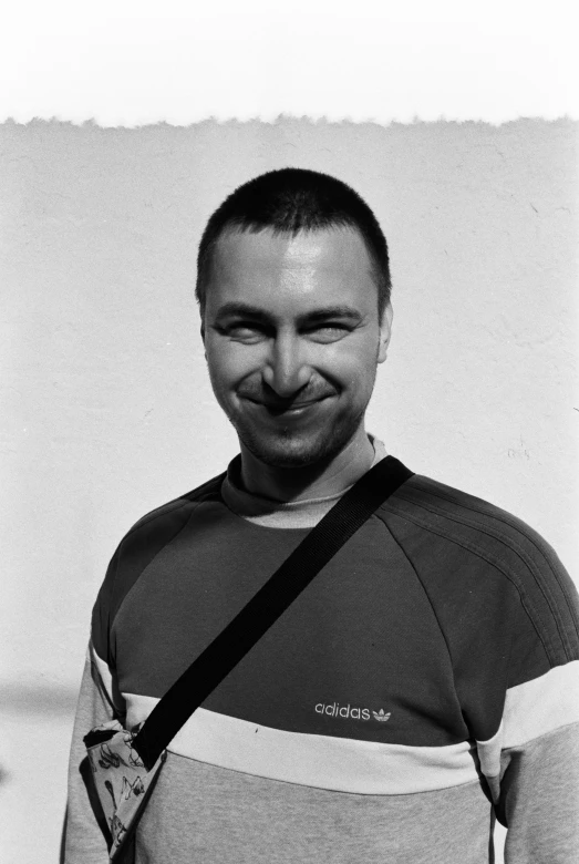 a man smiling with his camera attached to his back