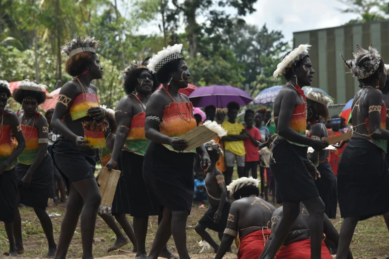 a group of people in native garb dance around