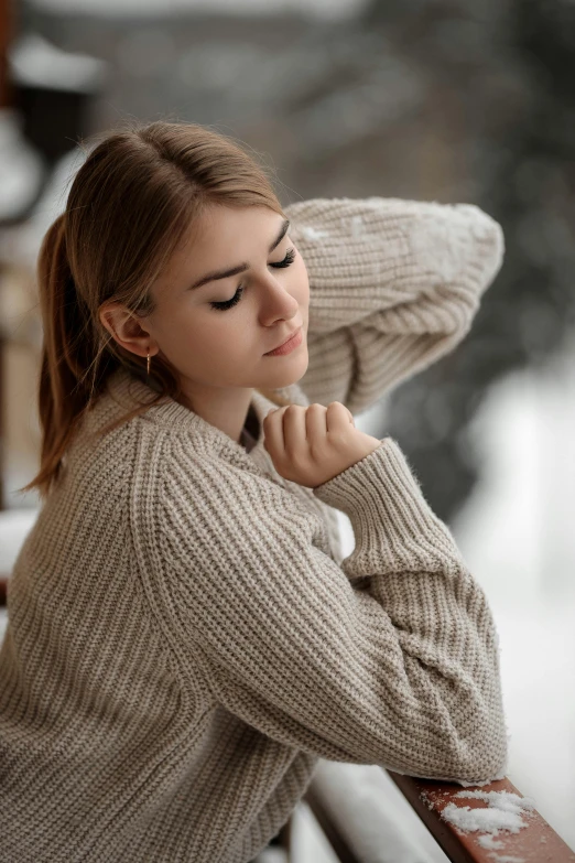 a woman leaning against a fence looking off into the distance