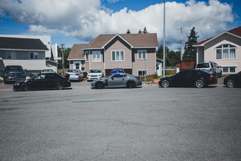 cars parked in a lot with a line of houses and buildings