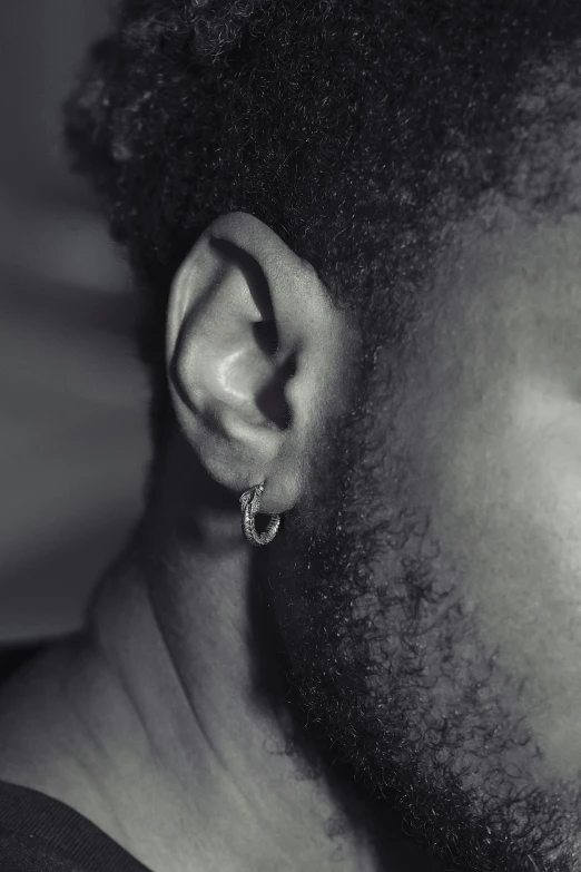 black and white po of a man with a beard and a single earring