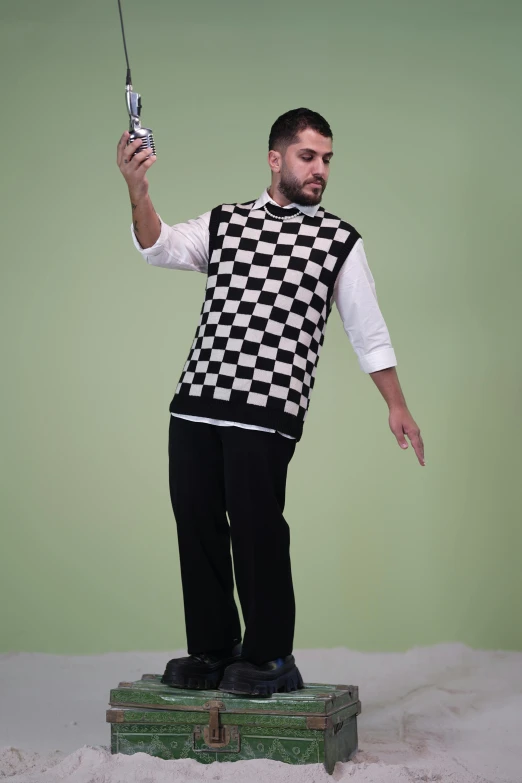 a man standing on a crate holding a cell phone