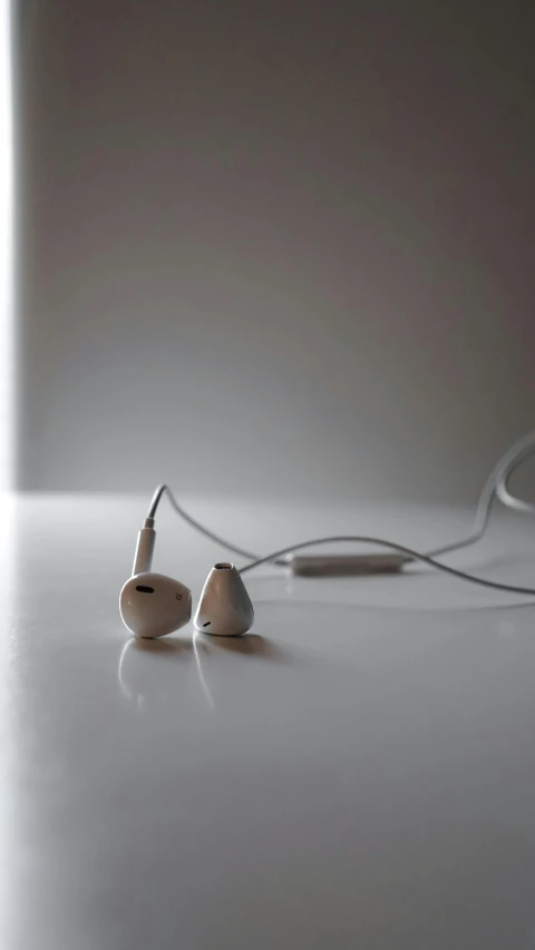 two earphones sitting on the floor next to a light